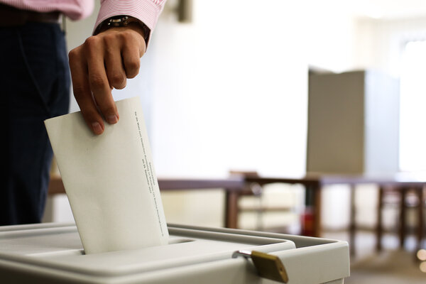 Wahlzettel wird in Urne geworfen