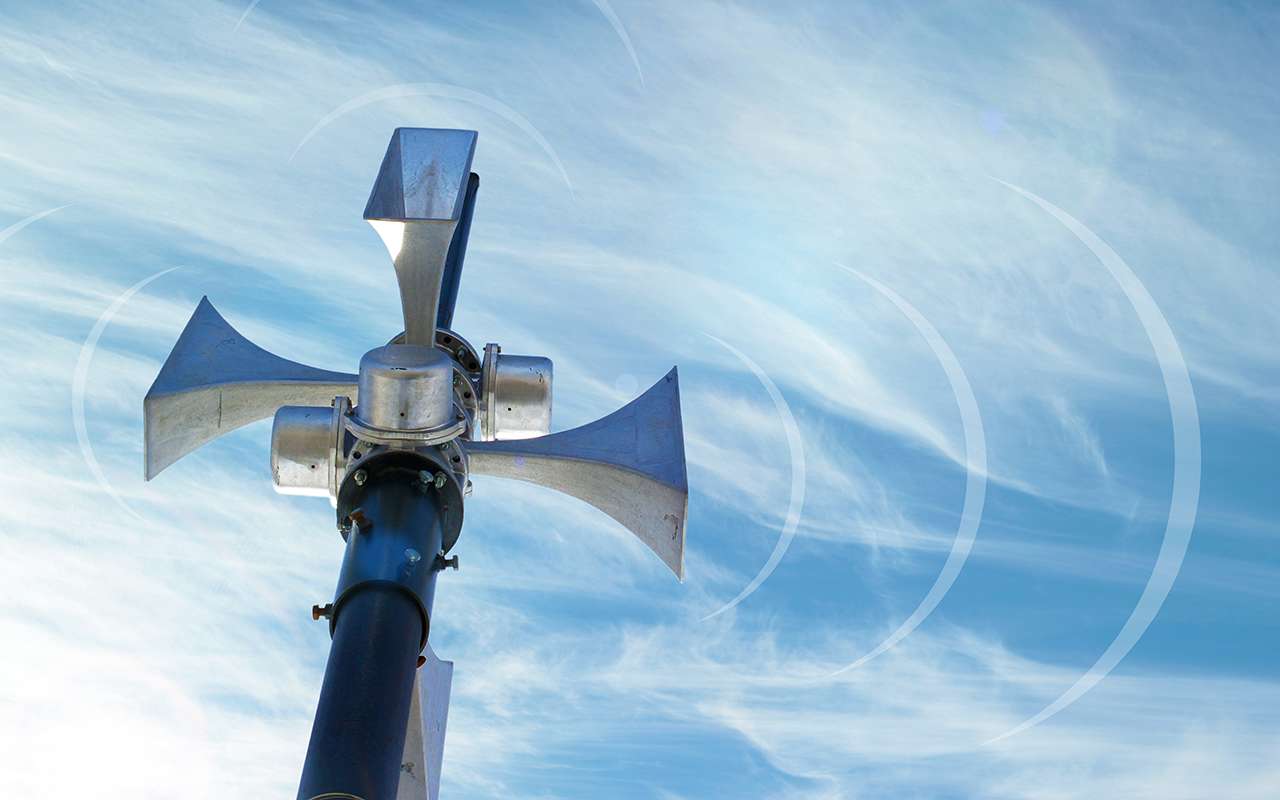 Outdoor loudspeaker against the background of blue sky, sound waves.