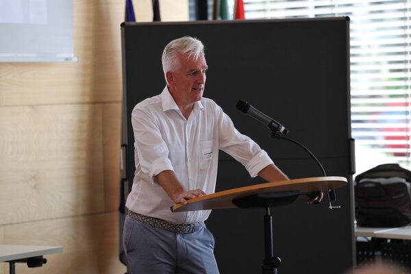 Gesundheitsdezernent Sven Brüggenhorst steht an einem Redepult und spricht in ein Mikrofon. 