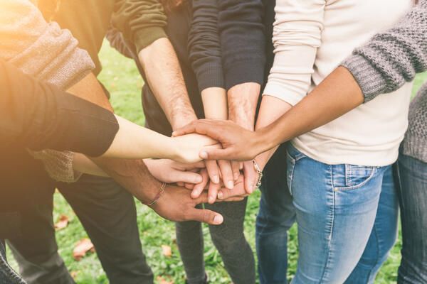 Bild vergrößern: Menschen mit aus verschiedenen Kulturen halten die Hände zusammen