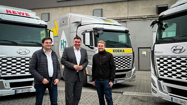 Landrat Mario Löhr (Mitte) mit Heinrich und Felix Wüllhorst vom gleichnamigen Familienunternehmen in Selm. Die Firma Wüllhorst Fahrzeugbau lieferte jetzt die ersten mit Wasserstoff betriebenen Lastwagen an Kunden aus.