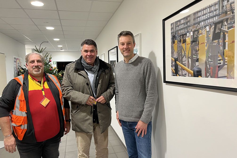 Bild vergrößern: Landrat Mario Löhr zu Besuch im Fulfillment Center im Logistikpark an der A2 in Bergkamen – hier mit Niederlassungsleiter Markus Happe (links) und Marco Brüggemann (rechts), BusinessUnit Direktor eCommerce.