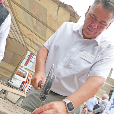 Landrat Löhr am Stand eines Dachdeckers.