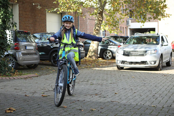 Kind auf einem Fahrrad biegt in eine Richtung ab