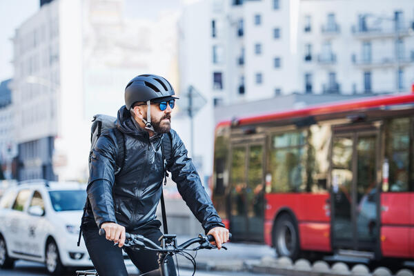 Male courier with bicycle delivering packages in city. Copy space.