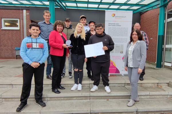 Bei der Übergabe der Medaille: Kommissarischer Schulleiter Kay Eckebrecht (hinten links) mit den Schülerinnen und Schülern, Sylvia Engemann, Beigeordnete der Stadt Selm (mit der Medaille), Organisatorin Heike Okroy (hinten Mitte), Schulsozialarbeiter Jens